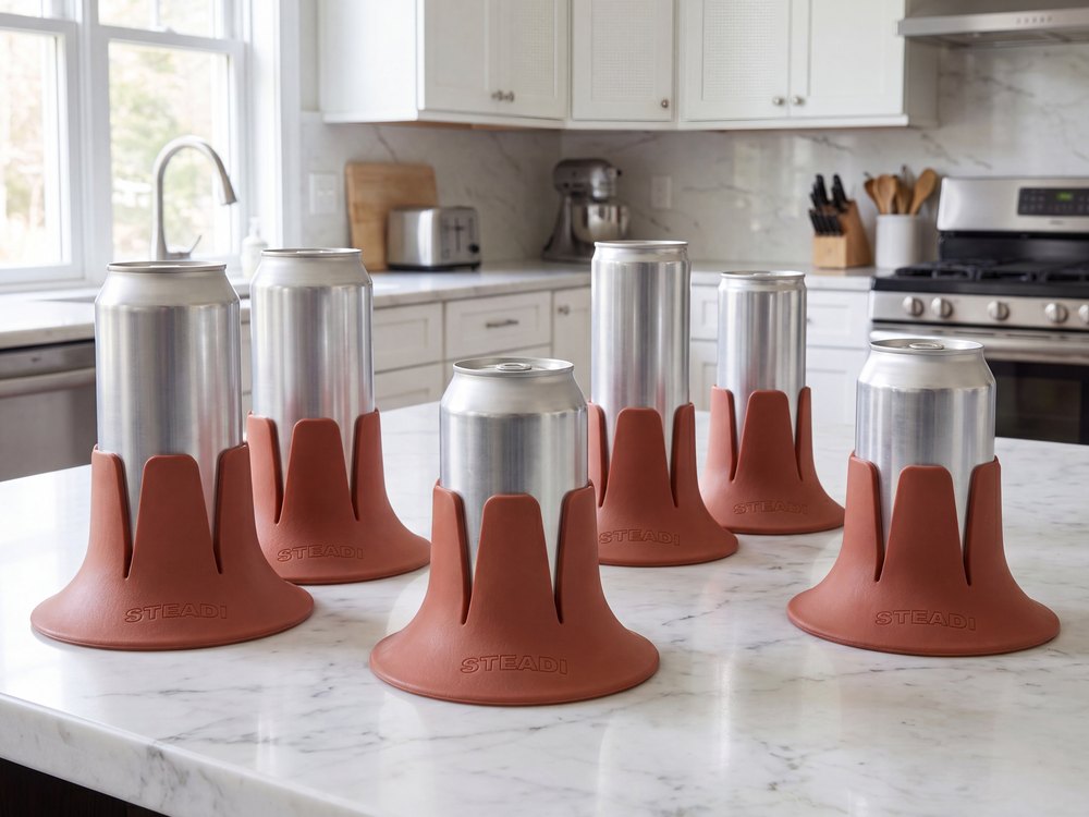 Several different cans, from a slim seltzer to a tallboy, each standing in a terracotta Steadi on a counter.
